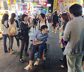 台湾で街角で人々と会話をする天畠さんの写真