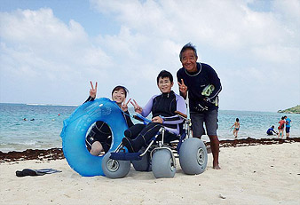 砂浜での家族と安藤さんの写真