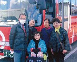 観光バスの前で伊藤さんを囲んだ記念撮影