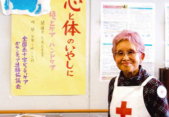 赤十字のエプロンをした笑顔の今野さんの写真