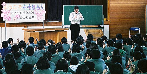 写真：大勢の子どもたちに教える井崎さん 
