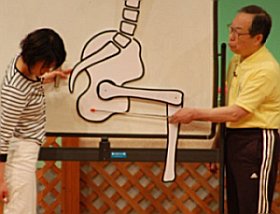 写真：ボードを使って腰痛が起こるしくみを解説する大田仁史さんと司会の河野多紀さん
