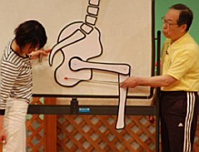 写真:ボードを使って腰痛が起こるしくみを解説する大田仁史さんと司会の河野多紀さん