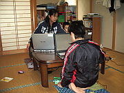 写真：パソコンを使って学習する子どもたち。傍らでスタッフが見守る