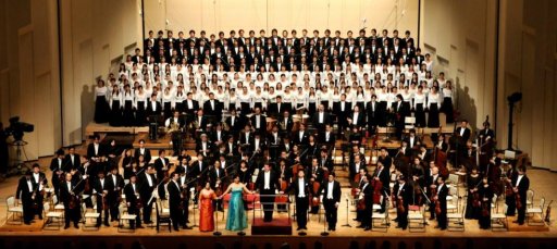 写真：NHKホールのステージにN響メンバーと4人のソリスト、合唱団がずらり並ぶ