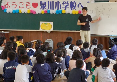 写真:いざきさんが、子どもたちの前で、こうわの説明をしている