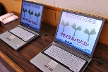 写真：贈呈されるリサイクルパソコン。画面には「わかば基金」の文字とわかばをイメージした絵がある