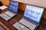 写真:贈呈されるリサイクルパソコン。画面には「わかば基金」の文字とわかばをイメージした絵がある