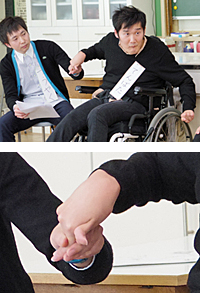 写真:てんばたさんとヘルパーさん。てんばたさんの腕の動きで言葉を伝えます