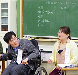 写真:1日目の宿題「話し言葉以外の伝える方法」を黒板に書き出す。手話。字を書いて見せる。点字。光と音。メール。表情