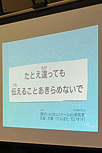 写真:てんばたさんの伝えたいこと。「たとえ違っていても、伝えることをあきらめないで」をスクリーンに映し出す