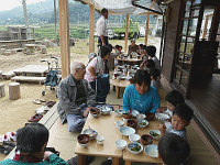 写真:縁側で近所の高齢者と園児が一緒にお昼ごはん