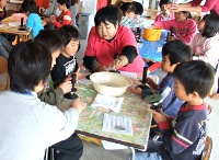 写真：子どもたちに石磨きを教えている