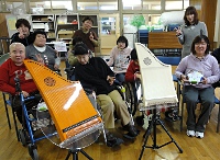 写真:車いすを利用している人たちがヘルマンハープの前で記念撮影。