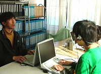 写真：視覚障害のある人が、パソコンを音声を聞きながら操作している。