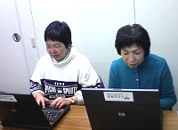 写真:パソコンで作業する会員の皆さん。