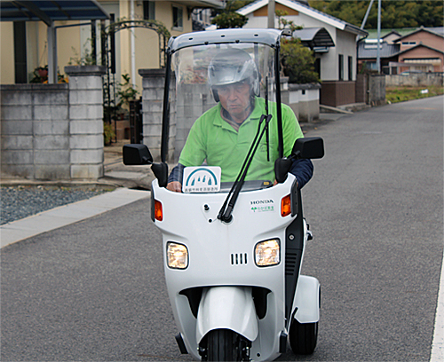 写真：三輪バイクで配達中